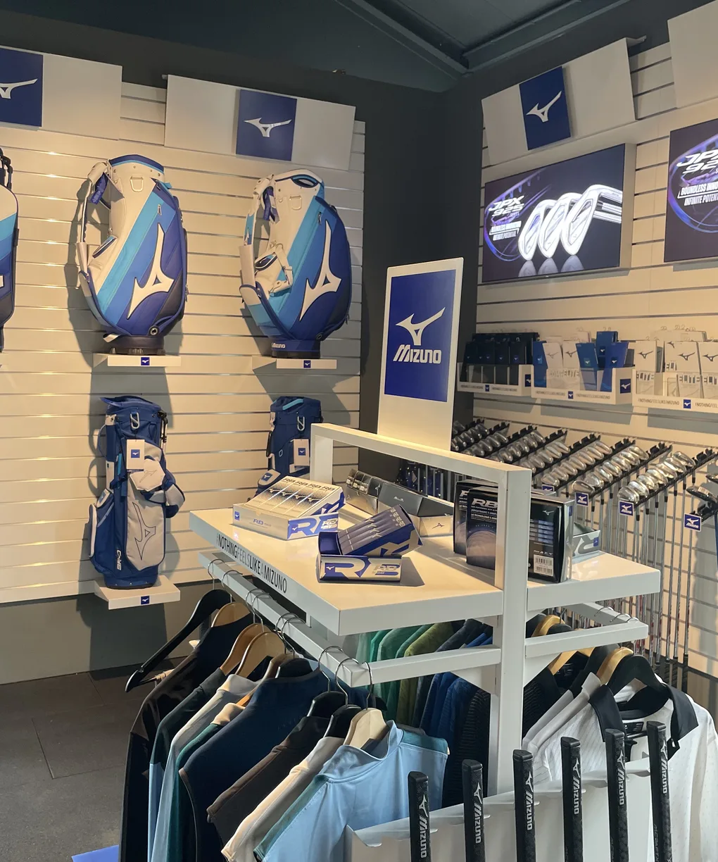 De Mizuno-wand in onze winkel met golftassen, ijzers, drivers en golfkleding